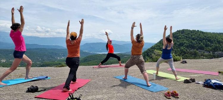 Des femmes en train de participer à un cours de yoga au cœur des massifs montagneux